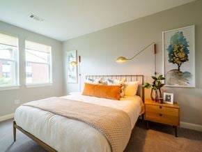 Lowell apartment for rent - A cozy and well-lit living space that opens to a bedroom with soft furnishings and chic lighting.
