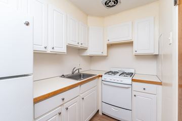 Melrose apartment for rent - A white kitchen with a stove, sink, and cabinets.