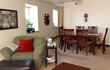 Pittsburgh apartment for rent - A living room with a green couch and a wooden dining table.