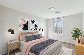 Branford apartment for rent - a bedroom with a bed and paintings on the wall at Shoreline Grove Apartments in Branford CT.
