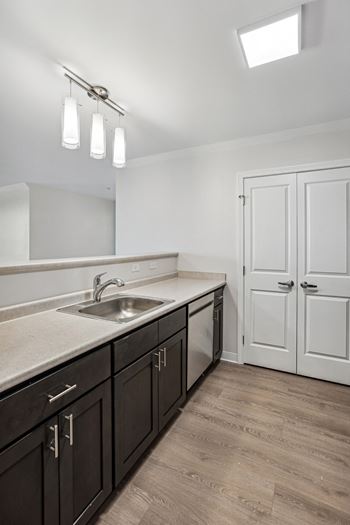 An empty kitchen with a stainless steel sink and counter top