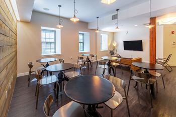 A dining room with tables and chairs and a tv