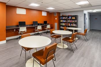 A common room with tables and chairs and a library