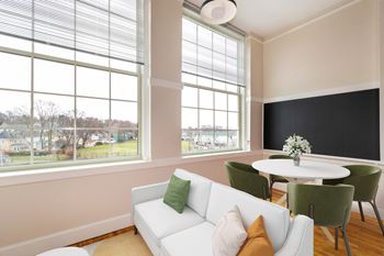 A living room with a white couch and a table with chairs