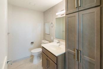 A bathroom with a toilet, sink, and mirror