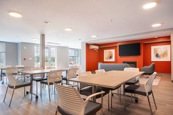 A dining room with tables and chairs and a tv