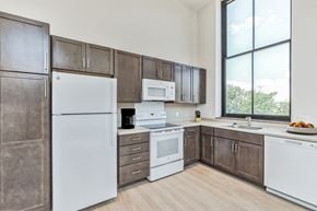 Pittsburgh apartment for rent - a kitchen with white appliances and brown cabinets and a window at Letsche School, Pittsburgh