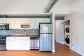 North Easton apartment for rent - a kitchen with white cabinets and stainless steel refrigeratorat Ames Shovel Works Apartments, Massachusetts, 02356