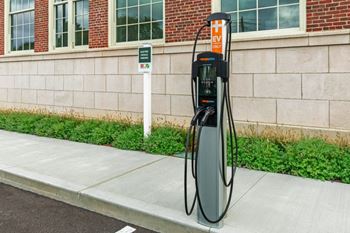 A gas pump on the sidewalk in front of a building