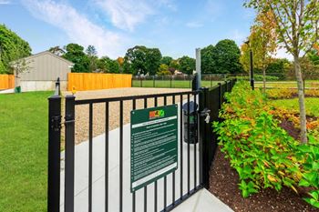A gate with a sign on it in front of a garden