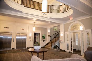 A large, well-lit foyer with a staircase and a cactus on the table
