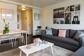 A living room with a couch coffee table and a dining table