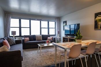 A living room with a tv and a table and chairs