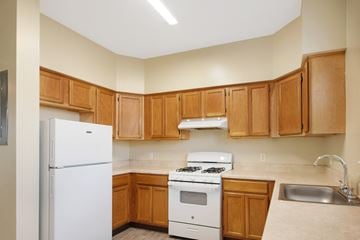 Niagara Falls apartment for rent - A kitchen with wooden cabinets and white appliances.