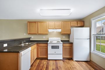 Niagara Falls apartment for rent - A kitchen with wooden cabinets and white appliances.