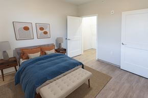 Menands apartment for rent - A bedroom with a bed, nightstand, and two framed pictures on the wall  at 35 Broadway Apartments, Menands, New York
