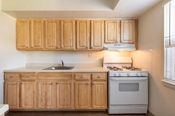 Hyde Park apartment for rent - A kitchen with wooden cabinets and a white stove.