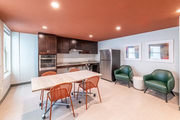 Boston apartment for rent - a dining room with a table and chairs and a kitchen with a refrigerator