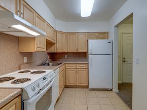 Ulster Park apartment for rent - Kitchen Layout With Wood Cabinets And White Appliances at The Birches at Esopus, Ulster Park