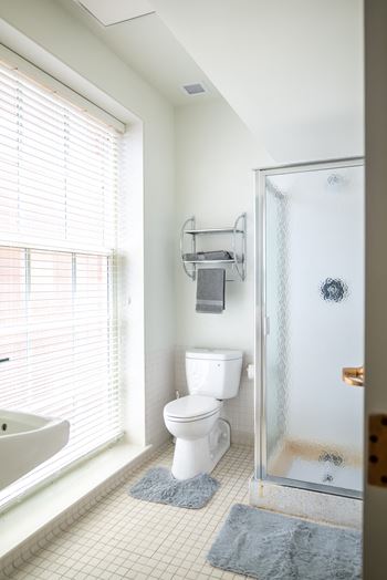 A white bathroom with a shower toilet and sink