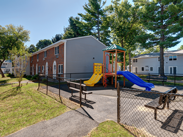 Springfield apartment for rent - A playground with a yellow slide and a blue slide.