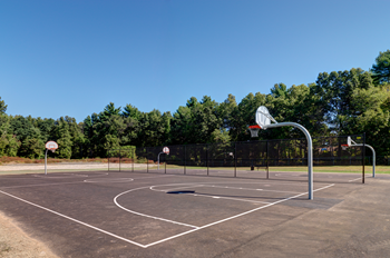 A basketball court with a hoop and a sign on the ground