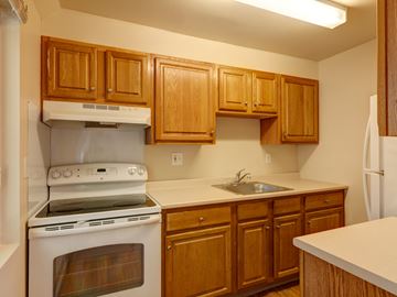 Brockton apartment for rent - a kitchen with wooden cabinets and a stove and a sink