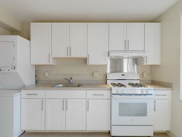 Boston apartment for rent - a kitchen with white cabinets and a stove and a sink