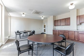 A meeting room with a table and chairs