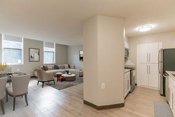 A kitchen and living room with a dining table and chairs