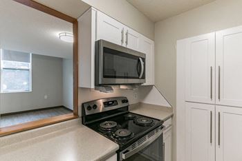 A kitchen with a black stove top oven and white cabinets