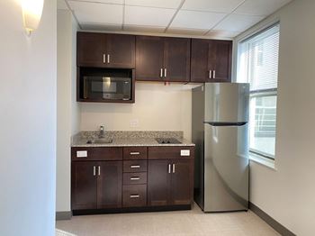 A kitchen with brown cabinets and a granite countertop
