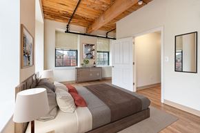 Haverhill apartment for rent - A bedroom with a bed and a lamp at The Cordovan at Haverhill Station, Haverhill, MA