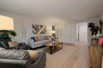 Harrisburg apartment for rent - A living room with a grey couch, a coffee table, and a large painting on the wall.