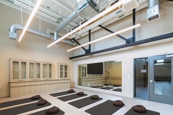 A yoga room with a large mirror and yoga mats on the floor