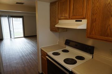 Union City apartment for rent - A kitchen with a stove top oven and wooden cabinets.