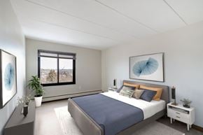 Worcester apartment for rent - A bedroom with a large bed and a window overlooking a mountainous landscape.