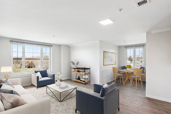 A living room with couches and chairs and a dining room table