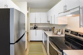 Canton apartment for rent - a kitchen with white cabinets and stainless steel appliances and a black stove at Blue Hills Village, Canton, 02021