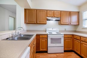 Ormond Beach apartment for rent - A kitchen with wooden cabinets and a white stove top oven Fishermans Landing Apartments in Ormond Beach, FL