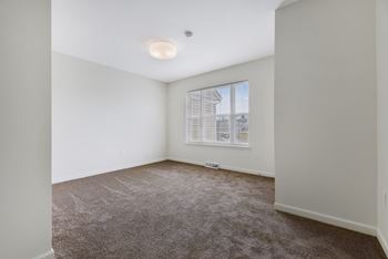 A bedroom with white walls and carpet