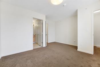 A bedroom with white walls and carpet