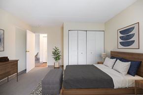 Stoughton apartment for rent - A bedroom with a bed and a dresser and a closet at North Stoughton Village Apartments in Stoughton, MA