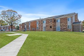 Columbus apartment for rent - A building with a stone facade and a green lawn in front.