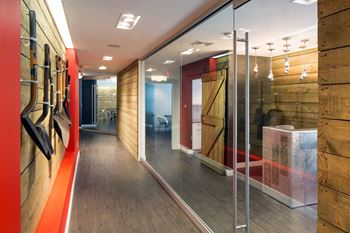A hallway with glass doors and a wall of reclaimed wood