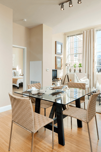 A modern dining room with a glass table and chairs