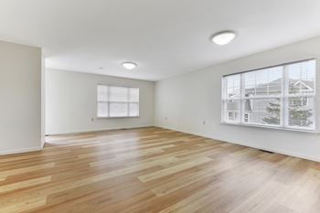 A bedroom with hardwood floors and white walls