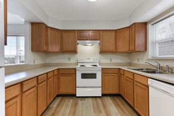 A kitchen with wooden cabinets and white appliances