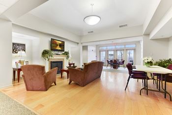 A living room with a fireplace and a dining room in the background