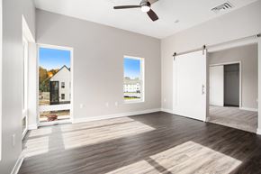 Hastings apartment for rent - A spacious room with a ceiling fan and two windows.